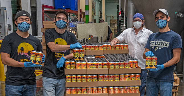 Group photo with pallet of cases of beer.