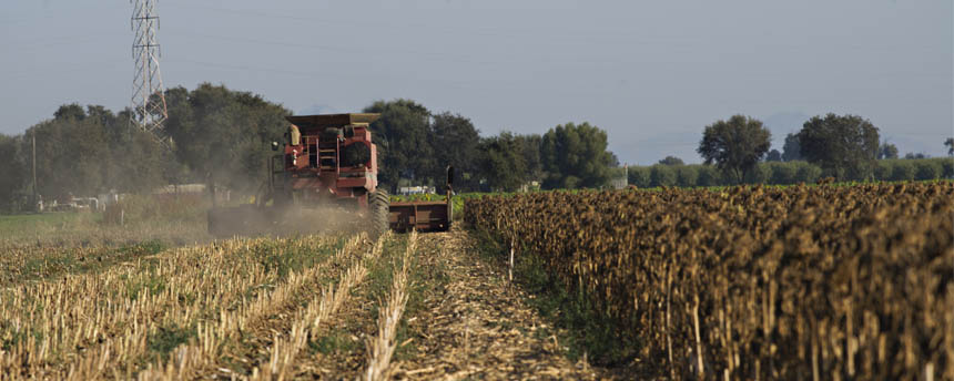 a tractor in a field stirs up a dust cloud that lowers air quality