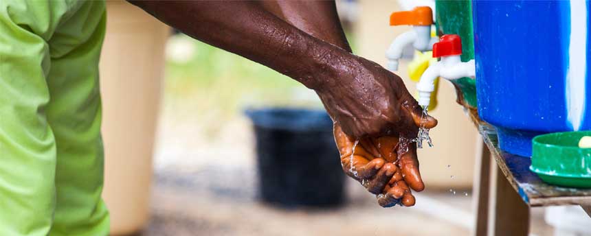 A man washes his hands from a water jug on a farm