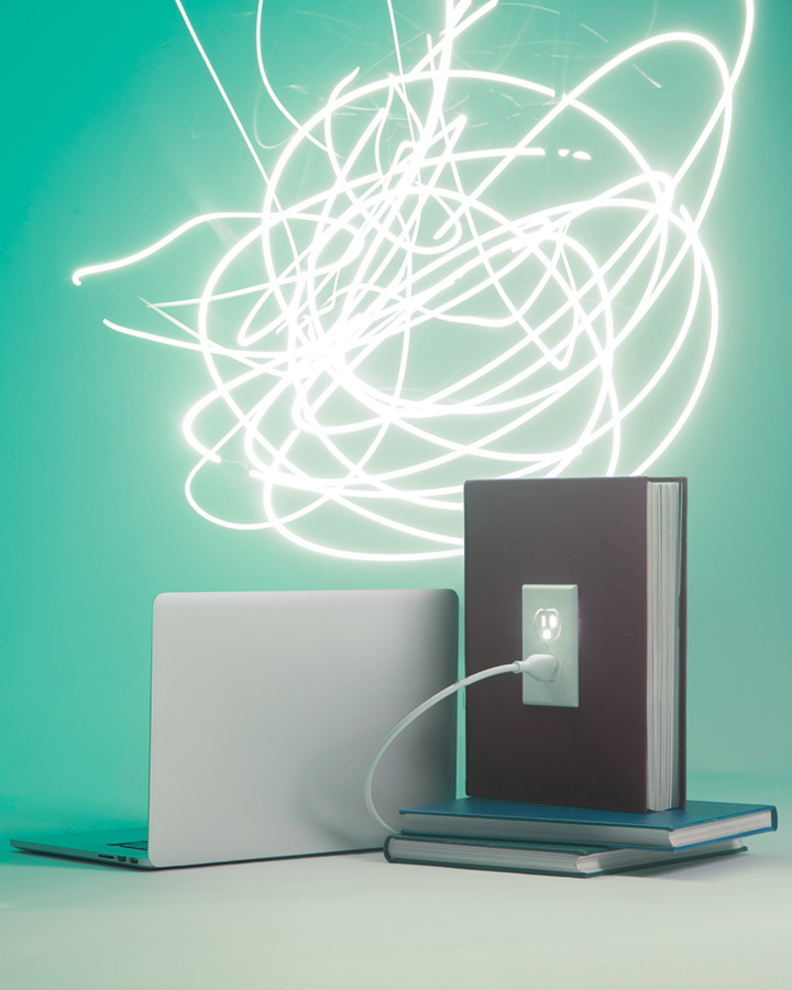 Conceptual photo of a laptop plugged into a book