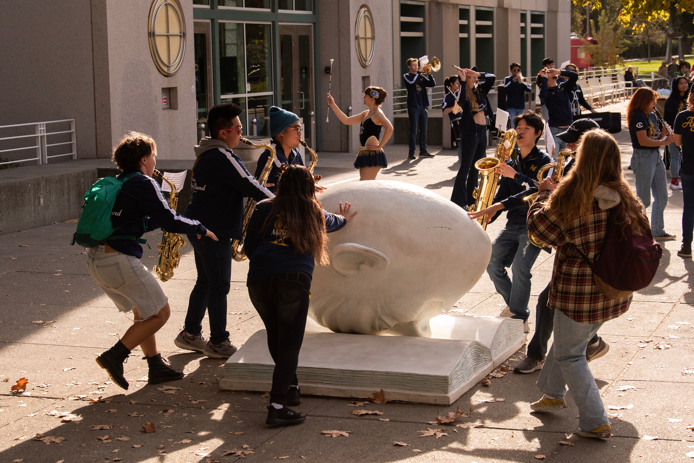 UC Davis Band member play their instruments and rub the Egghead for good luck.