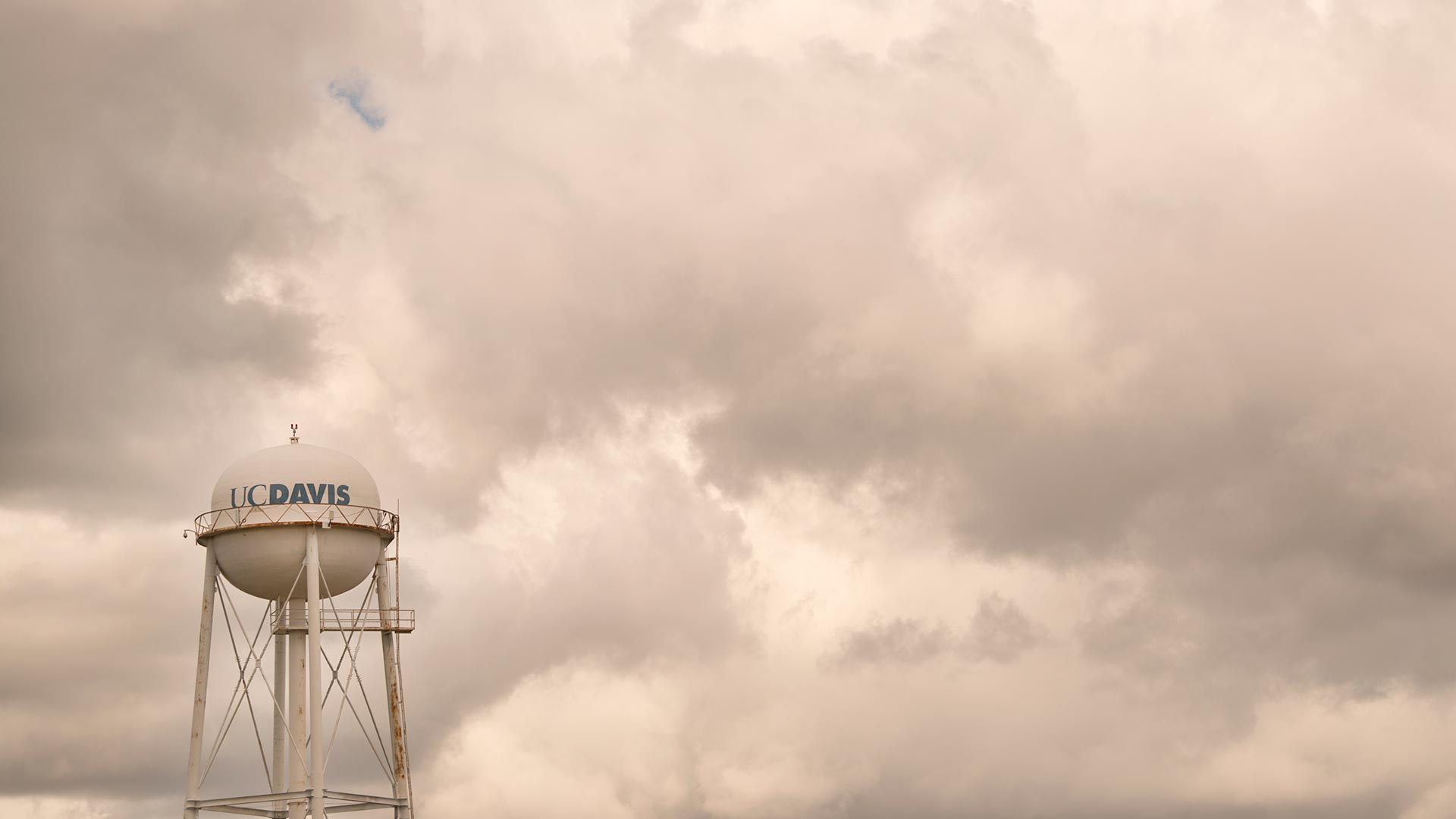 Large clouds dwarf one of the UC Davis water towers.