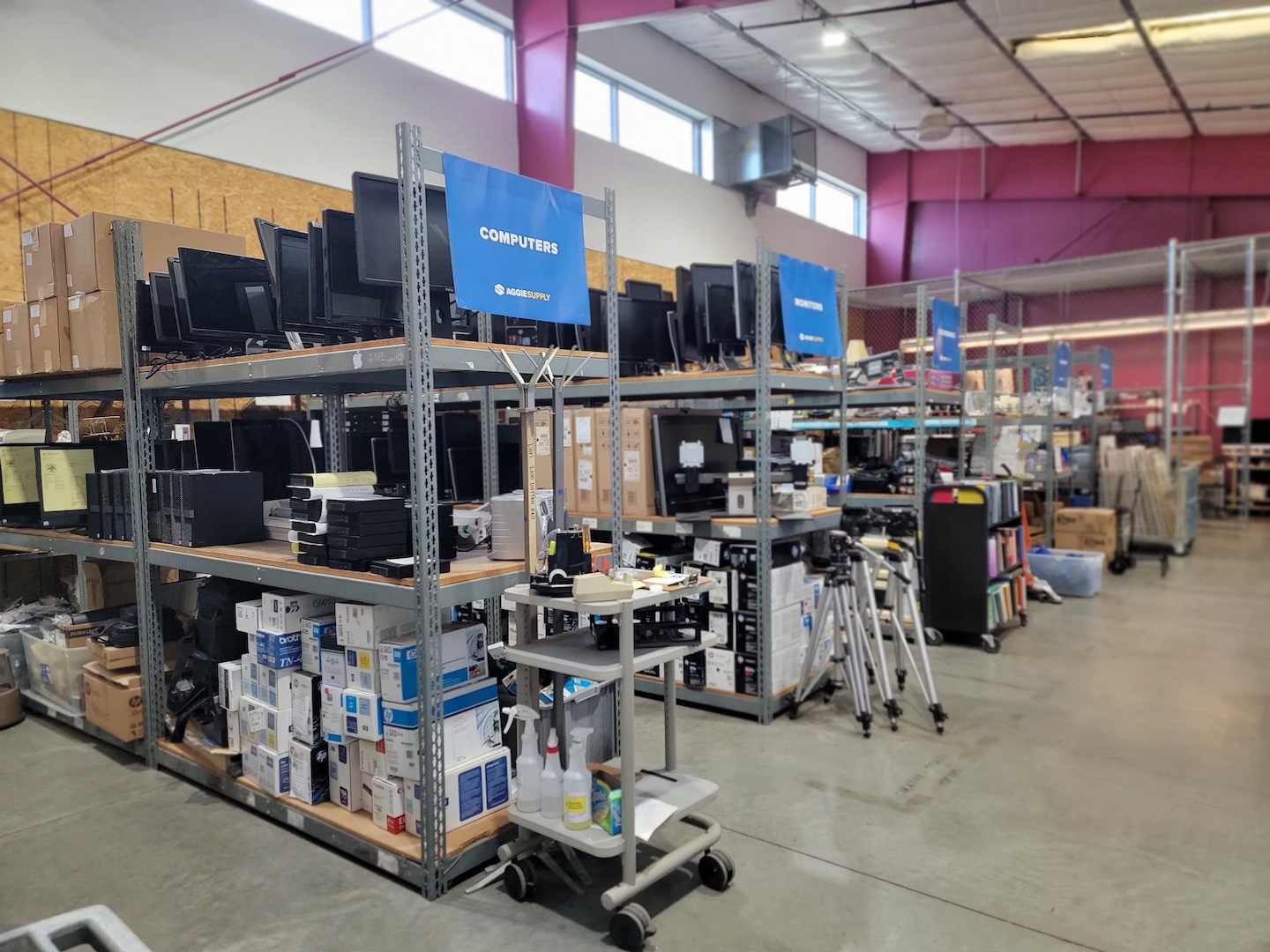 Rows of shelves labeled "computers," "monitors," and other items.  