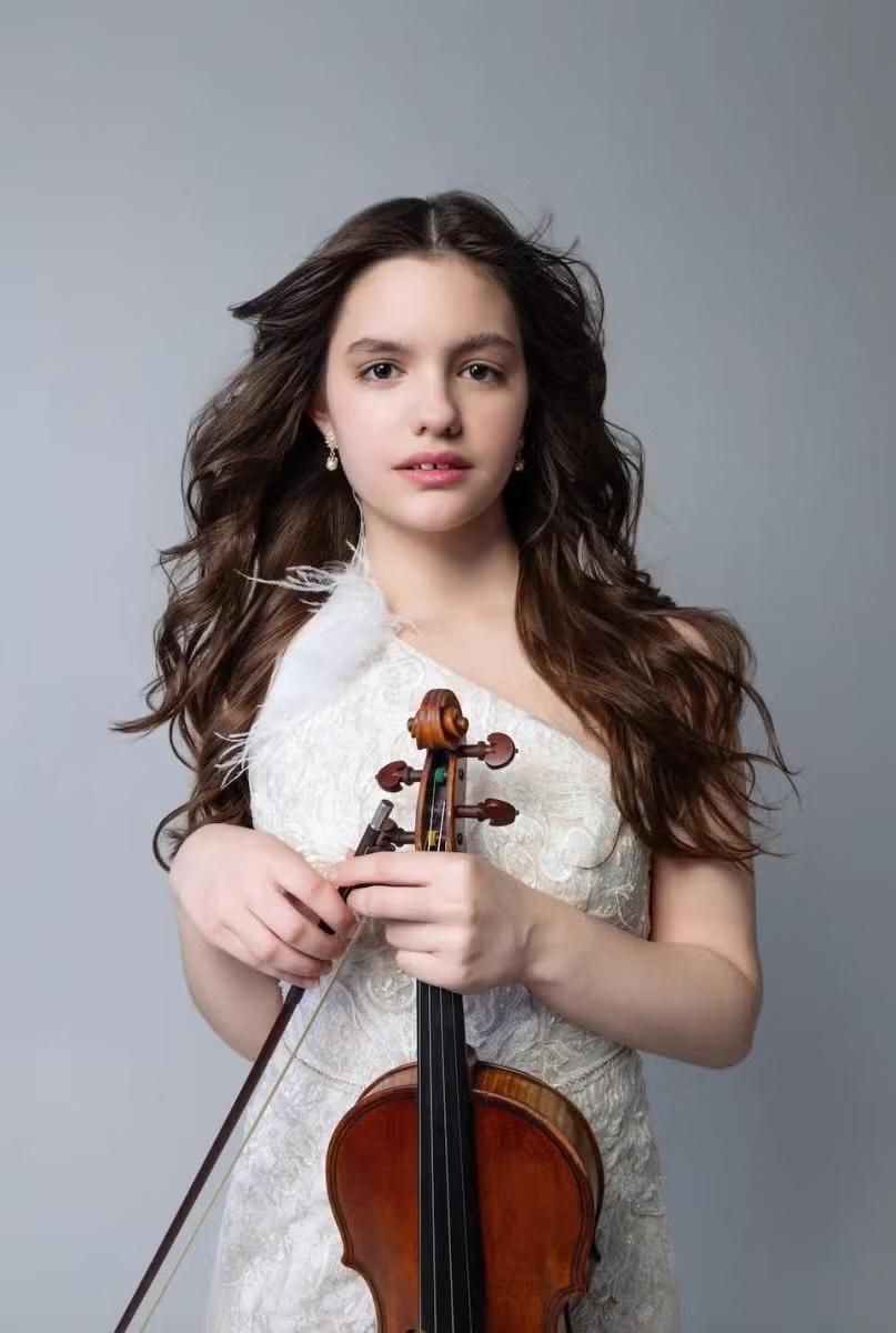 Girl dressed in white holding string instrument