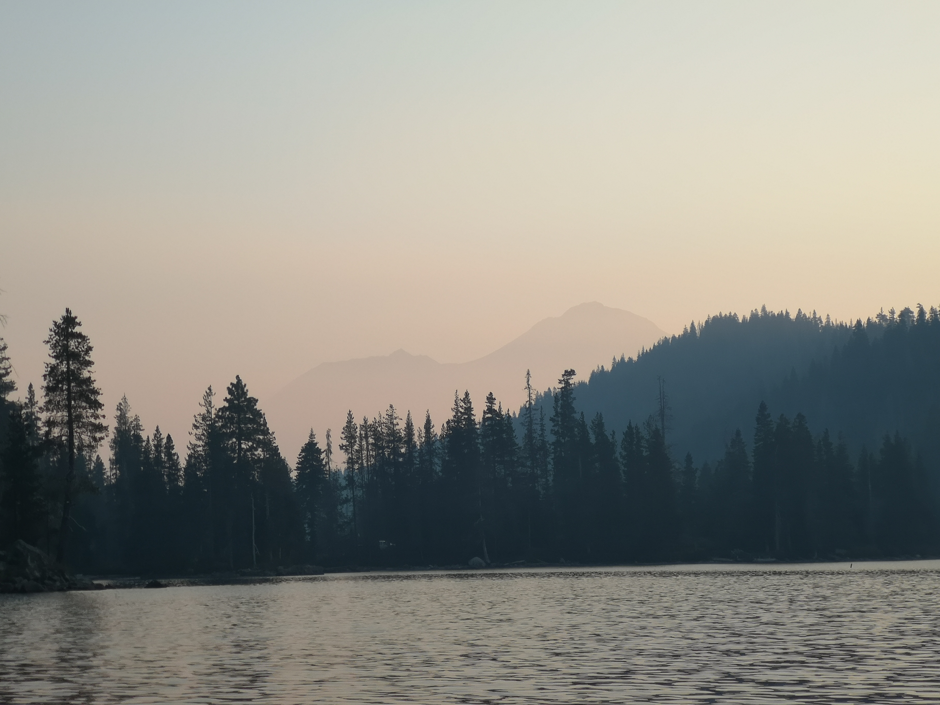 Smoke above Castle Lake with silhouette of mountains and trees 