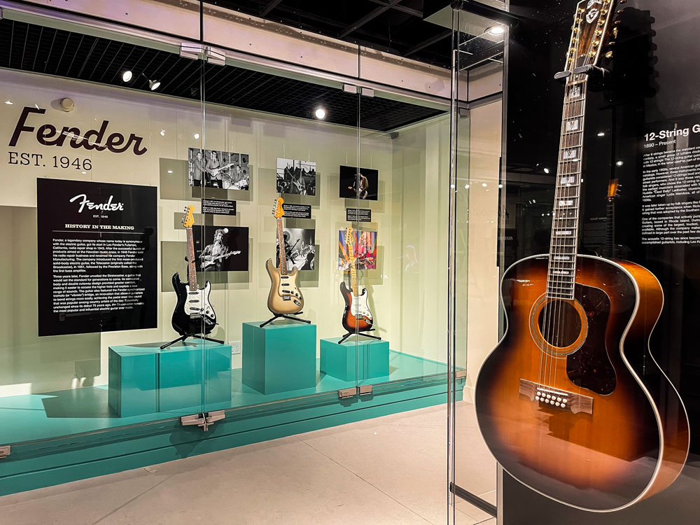 Guitars in California museum exhibition with Fender brand name in bold
