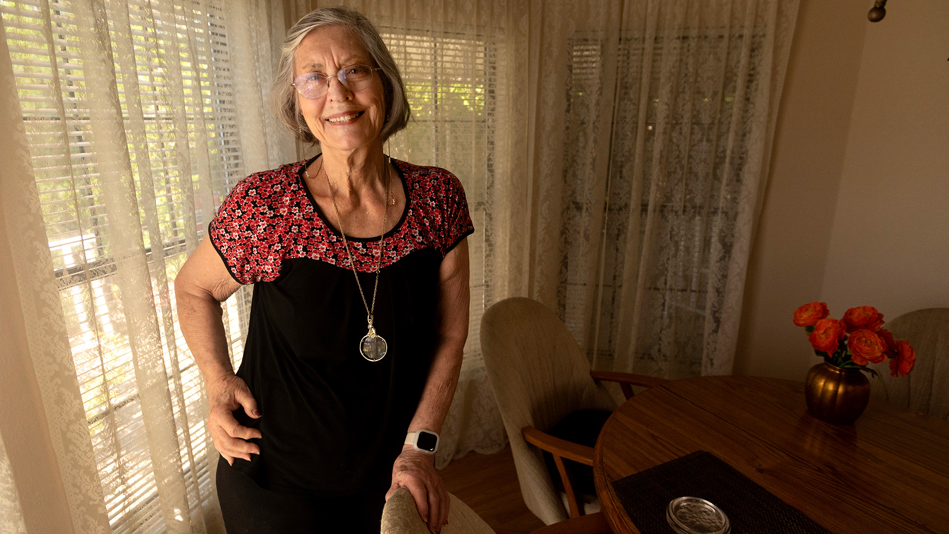 Older woman stands in dining room