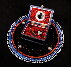 A decorative box with red interior, surrounded by a colorful circular design on a black background.