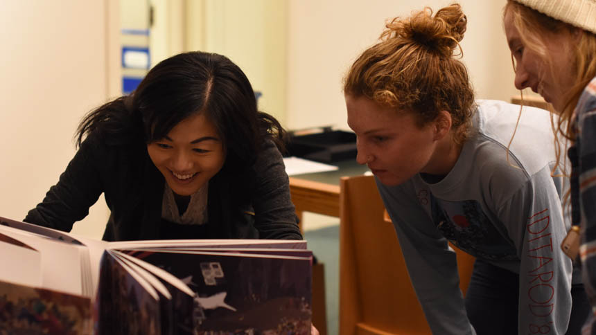 students looking at a book collection in the library