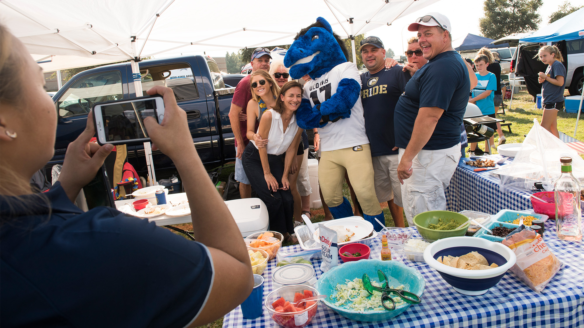 People pose for a photo with Gunrock at a tailgate.