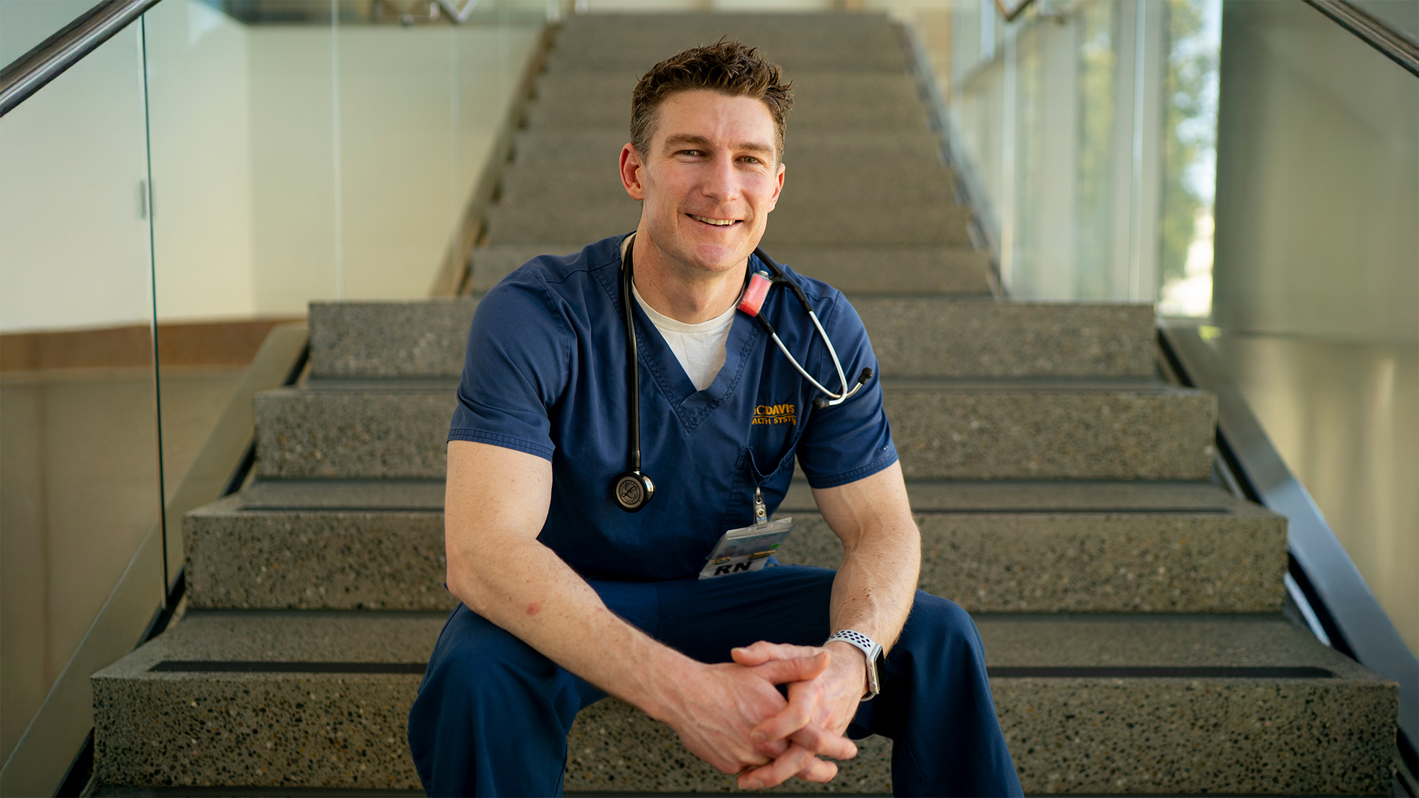 A nurse sitting on the base of a large staircase