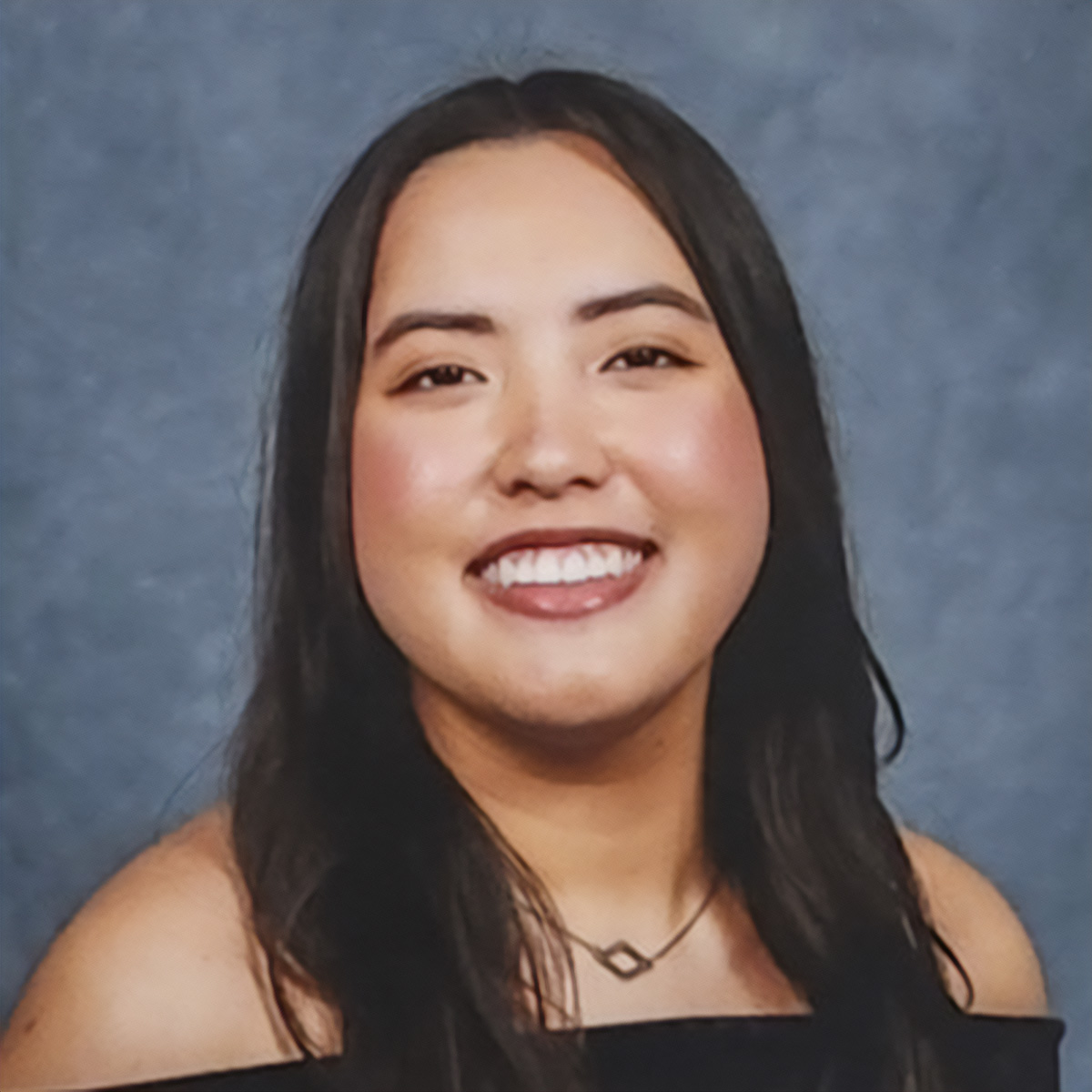 A profile picture of Jaylynn Velhagen-Dizon smiling with a neutral blue background
