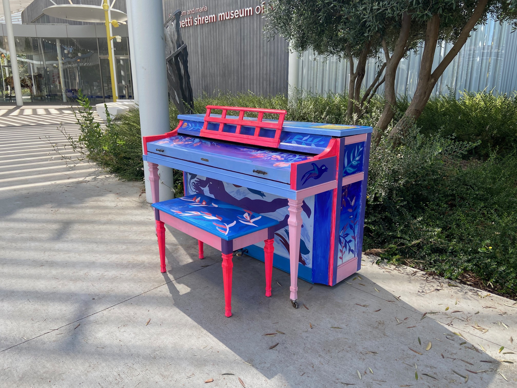 Colorful blue and pinkish hues decorate the piano in front of the Manetti Shrem Museum of Art