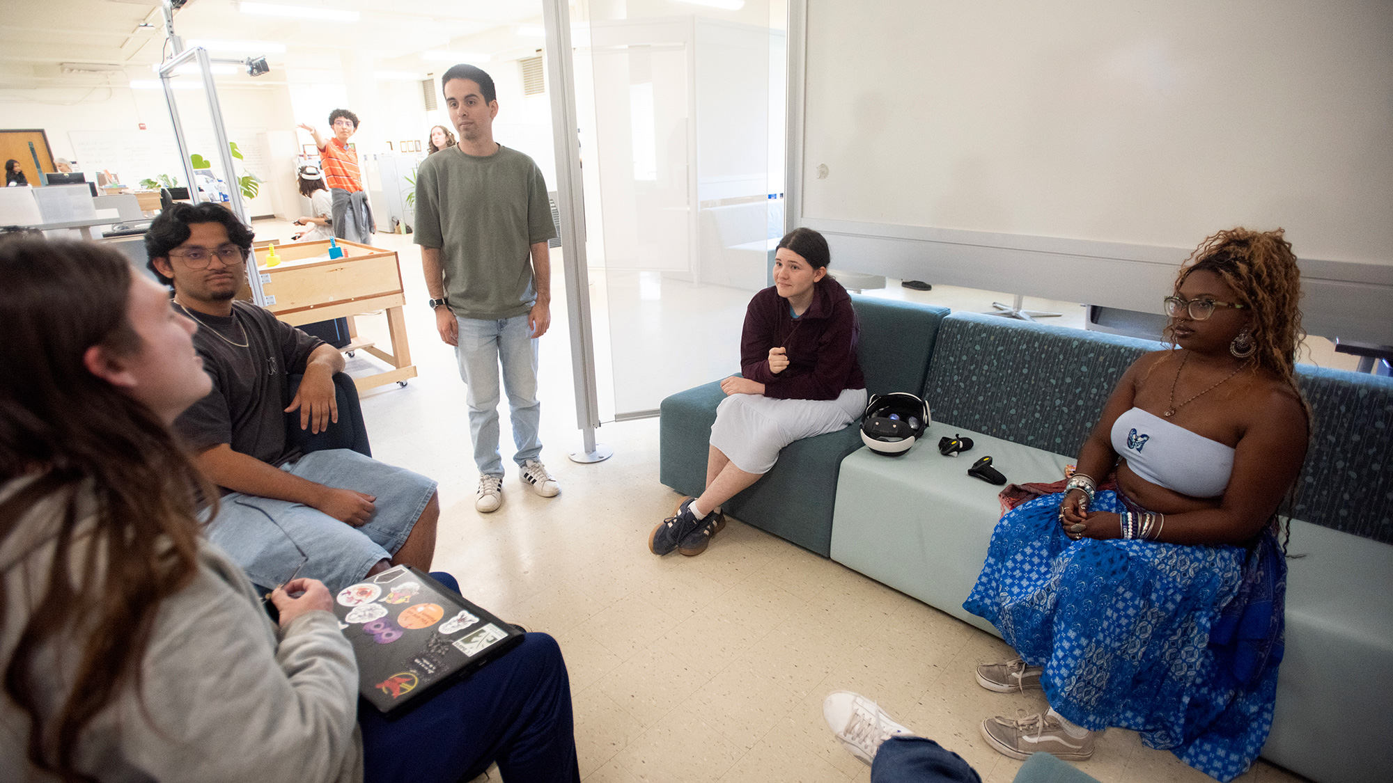 Classroom photo of diverse students seated in a circle, casually talking
