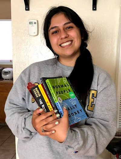 Tana Madrigal holds books.