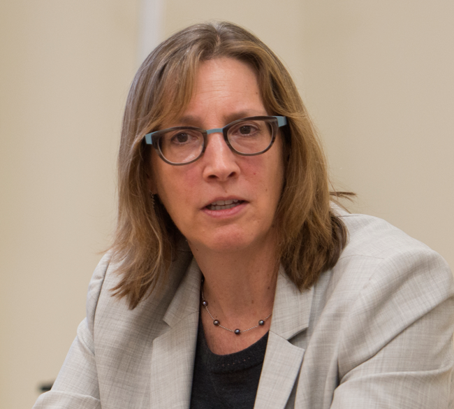 MacKenzie, seated, talking, at table