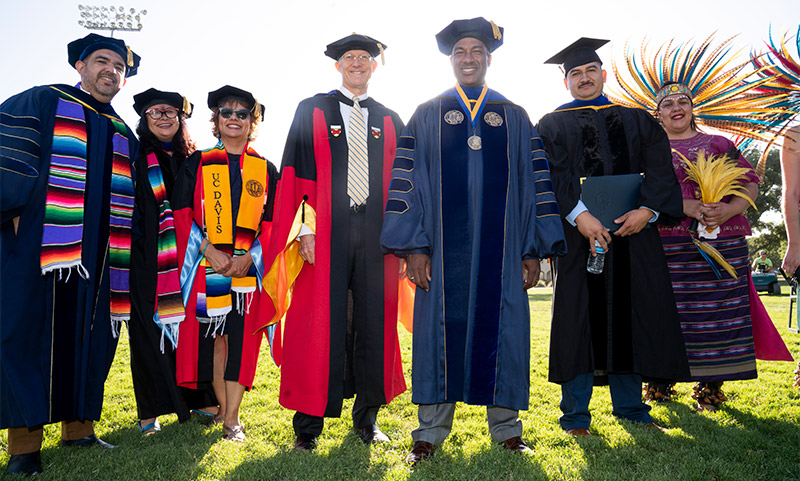 Chancellor Gary S. May poses for a photo with faculty members before the Chicanx Latinx Graduation.