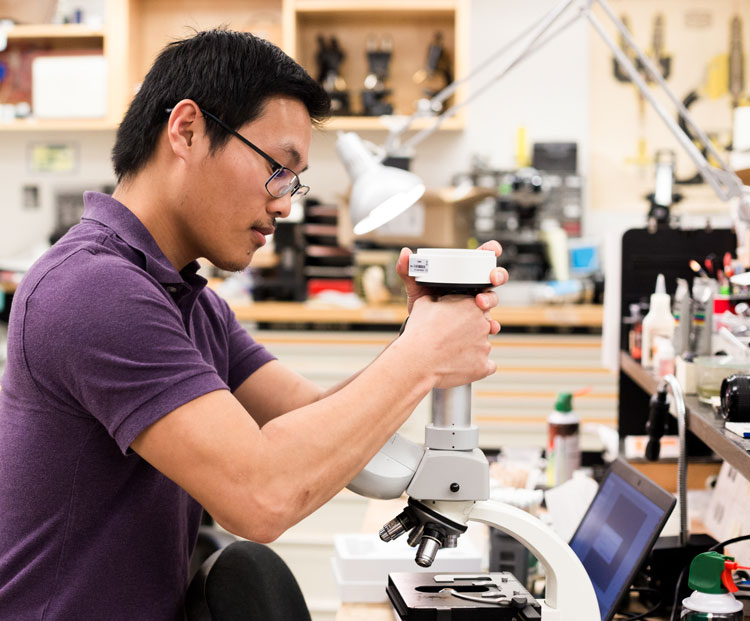 Eric Vang at bench, working on microscope