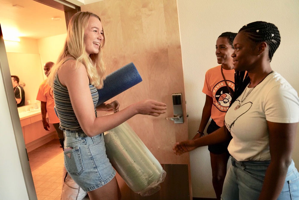 Two students meet each other outside suite.