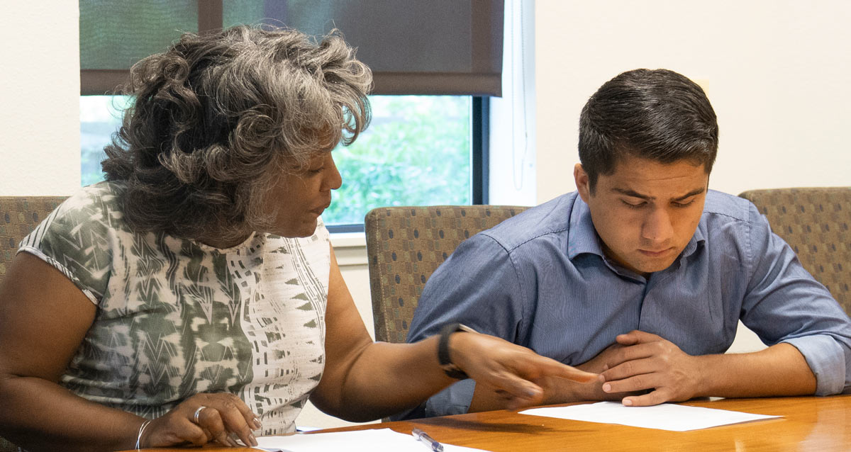 Emily Galindo at table with job shadow (male student).