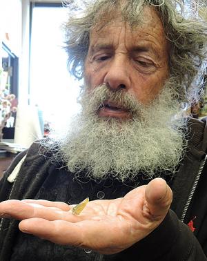 Man holds butterfly in palm of his hand.