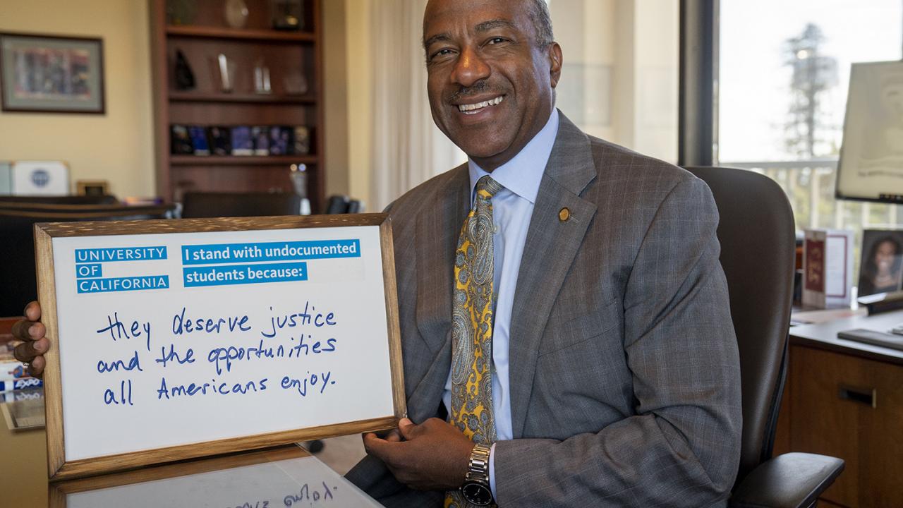 Chancellor Gary S. May with sign showing support for DACA students.