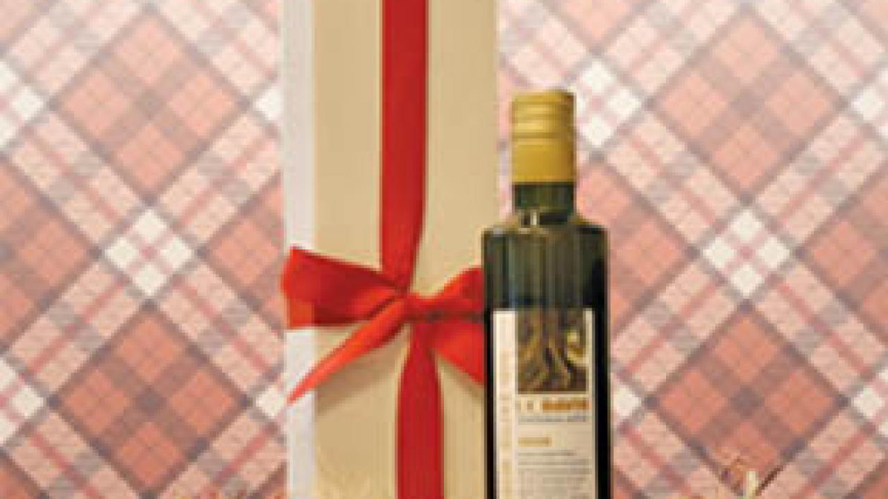 UC Davis Centennial Blend Olive Oil: Bottle with excelsior straw as packing, and a box with a red ribbon