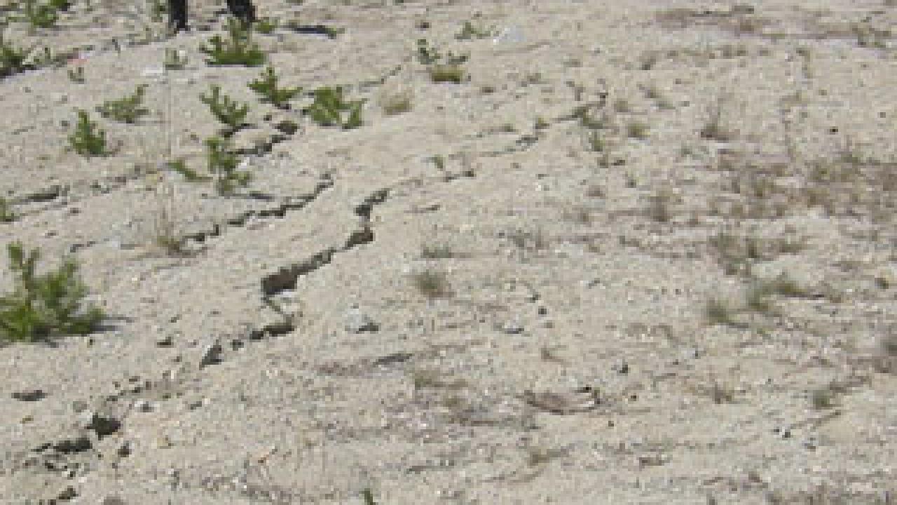 Photo: woman walking up scarred mountain side
