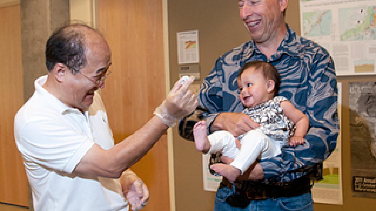 Geologist showing meteorite to baby and donor Gregory Jorgensen.