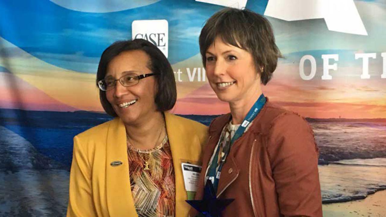 Dean Helene Dillard and Pam Pacelli, standing in front of themed backdrop.