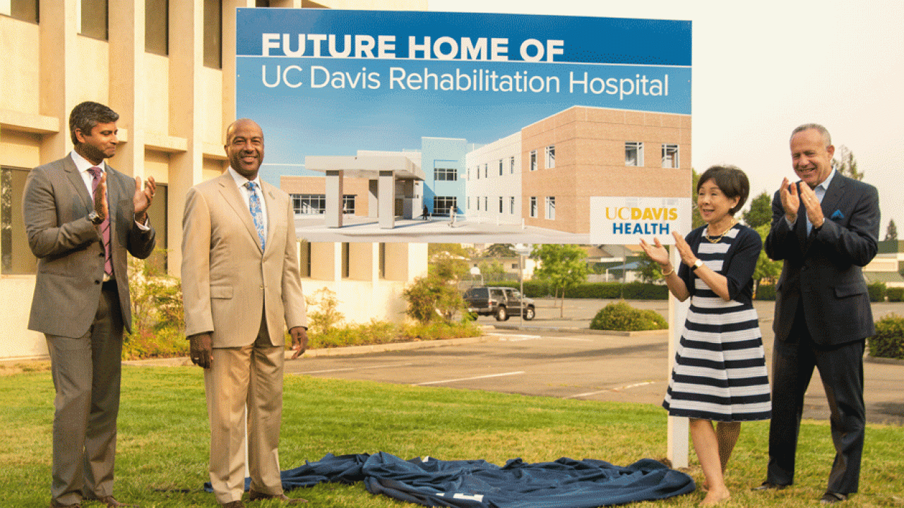 Dignitaries flank sign designationg "future Home of UC Davis Rehabilitation Hospital."