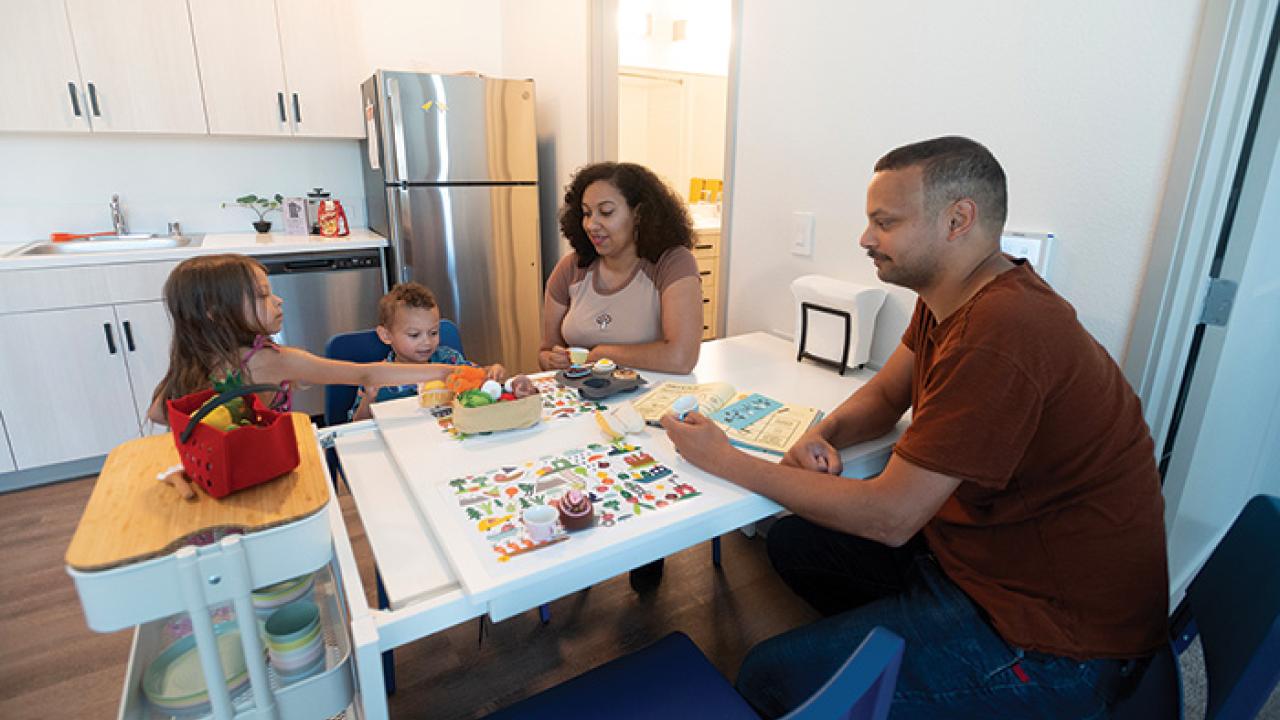 The Perrys inside one of the apartments at Orchard Park featuring an open-concept kitchen, dining and living area. (Gregory Urquiaga)