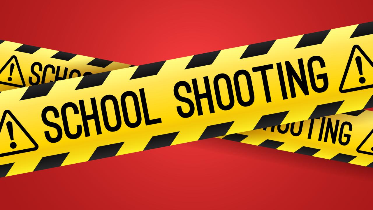 Crime scene tape in yellow with black writing saying "school shooting"