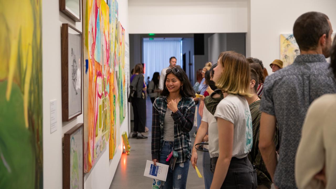 People at museum exhibition with art on walls