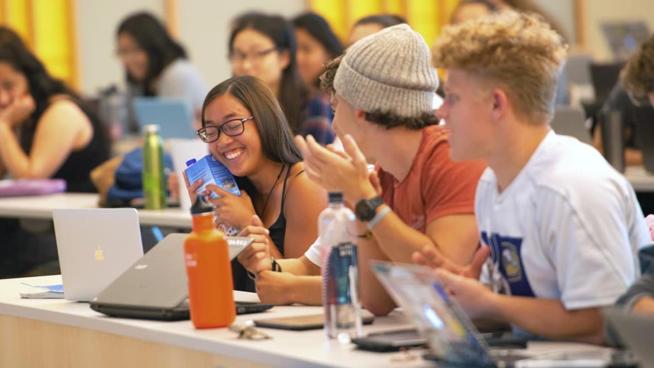 a group of students laughing in lecture hall