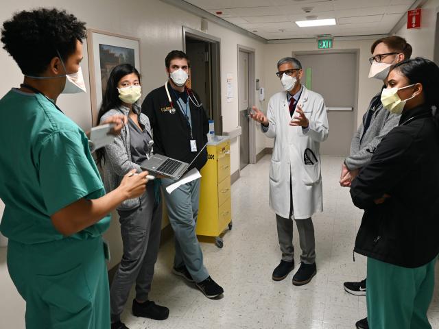 Doctor in a white coat talks with medical students in a hospital