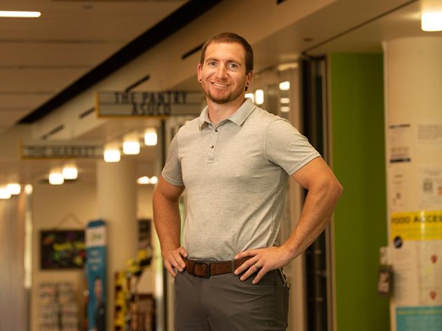 Man stands in hallway with hands on hips