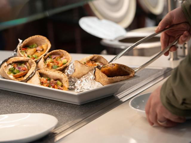 A UC Davis student grabs an empenada from the dining commons