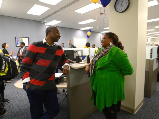 two staff members talking to each other in an office space