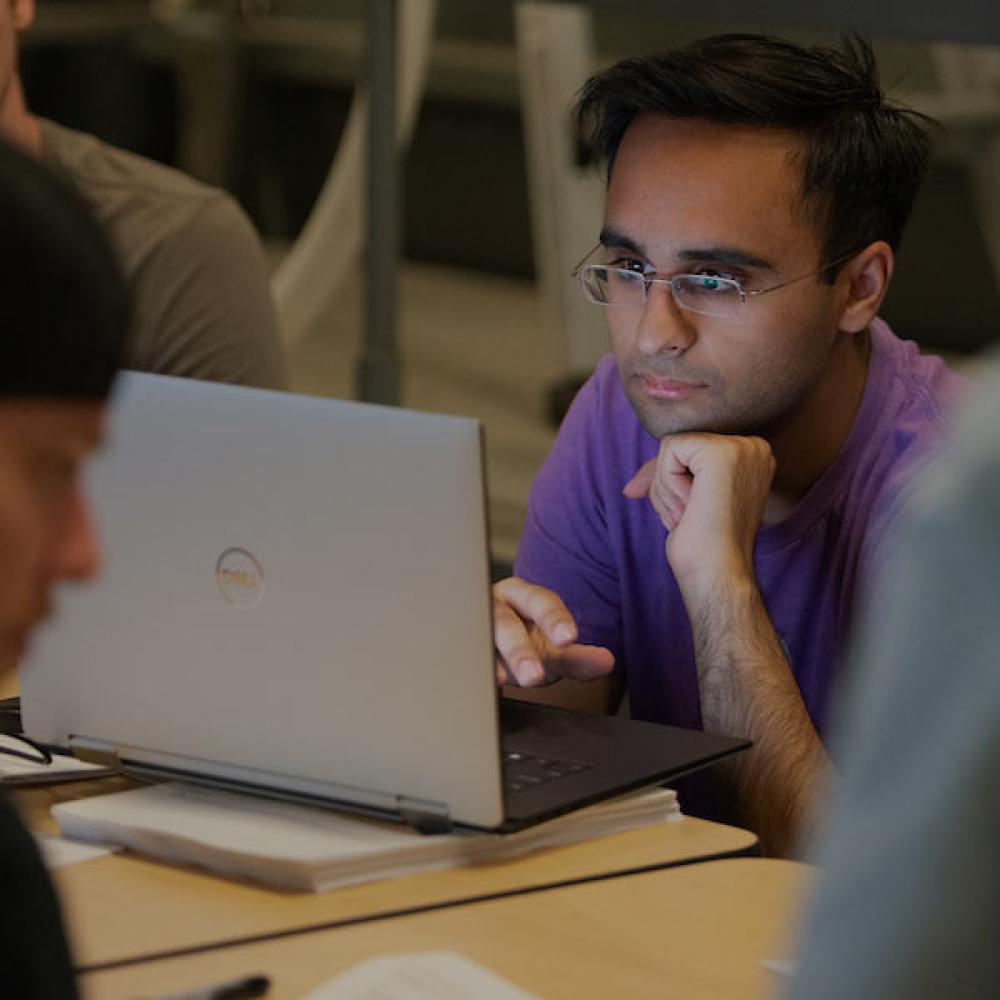 A male student working on his laptop.