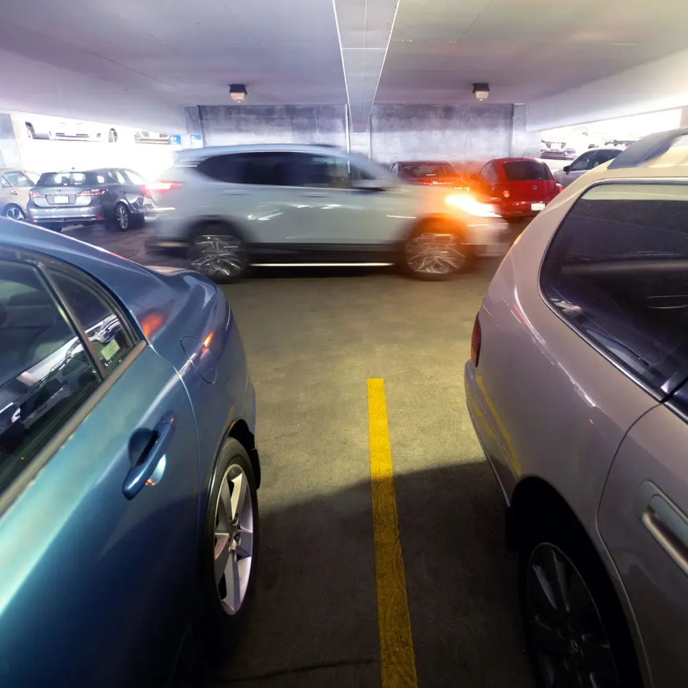 The sideview of a car driving in a parking garage
