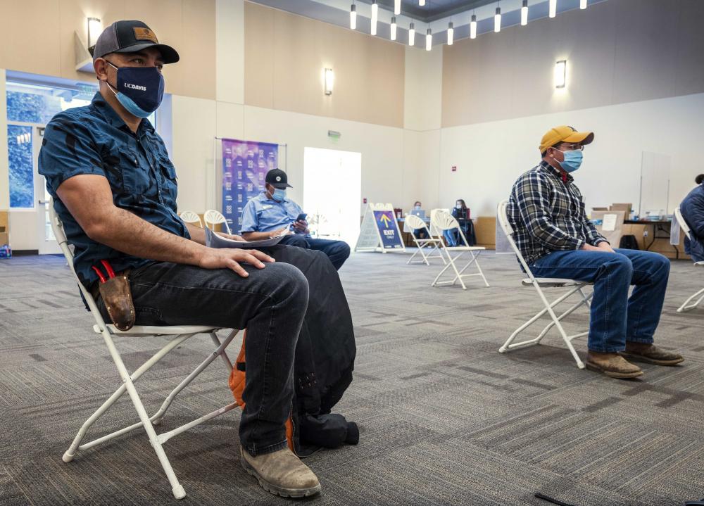 A few men sit in the ARC after getting vaccinated