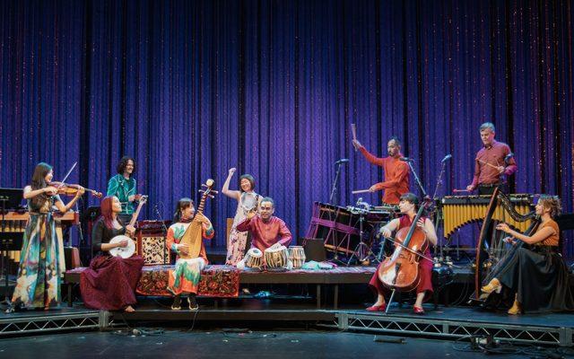 Ensemble on stage in colorful costumes.