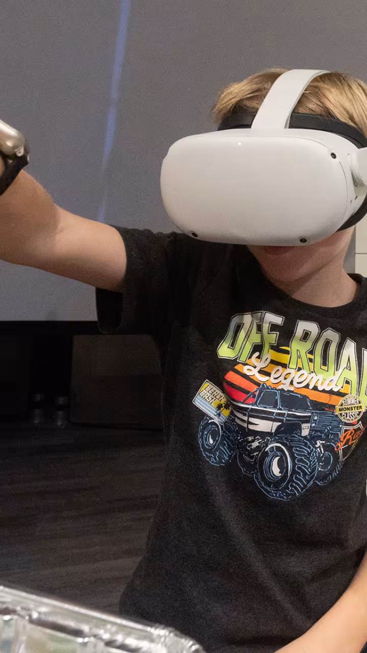 Child with a virtual reality headset on tries to solve a puzzle