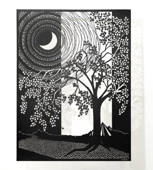 A paper-cut piece in black and white shows a tree and a moon.