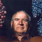 photo: Man holding two bunches of grapes
