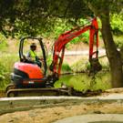 A new path and circular seating area take shape along the arboretum waterway.