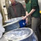 On the front: In the Tercero dining commons kitchen, Vincent Kemnitz, foreground, and Derek Stripling start the dishwashing process by scraping waste, including napkins, into a trough that carries all organic material to a grinder and then a pul