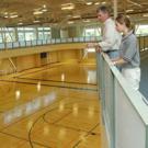 Rec Hall director Jim Rodems and student Rebecca Miller stand along a meandering track, surveying the main gym area inside the ARC.