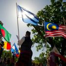 Parade participants carry flags of various nations.